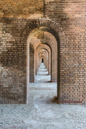 A vertical view through warm weathered brick archways at Fort Jefferson.