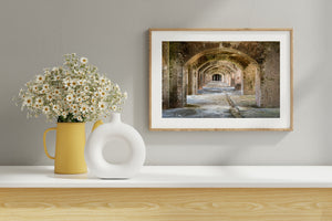 Light falls across worn flooring beneath the fort’s weathered brick vaults.