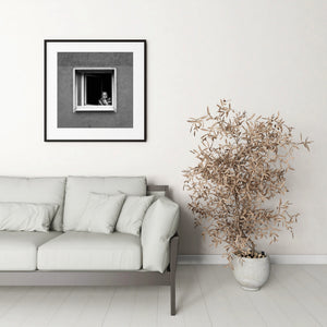 A quiet Frankfurt window scene with a striped shawl, pale frame and rough plaster wall.