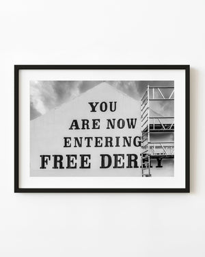 Black and white photograph of the Free Derry gable wall beneath cloudy skies