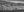 Panoramic Canadian landscape with a freight train between dark river water and rugged hills