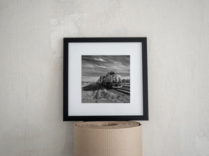 Locomotive 2948 travels through a grassy prairie landscape under dramatic clouds
