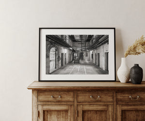 Monochrome prison architecture with barred doorway, cell entrances and upper walkways