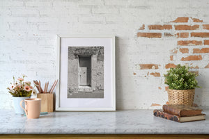 Rough stone textures frame a sunlit wooden doorway in an Australian prison