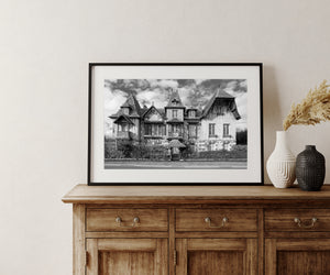 Black and white architectural photograph of a French mansion beside a quiet road