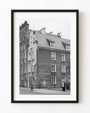 Historic brickwork and dormer windows line a Gdańsk street in a black and white architectural photograph