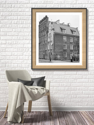 A historic Gdańsk streetscape shows tiled rooftops and an ornate brick façade in monochrome
