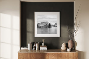 Gabled brick warehouses and a dark-hulled ship line a quiet Polish harbor