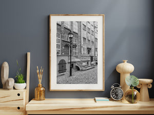 Stone steps and rounded posts lead toward a brick library entrance on Mariacka Street