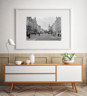 November pedestrians cross a broad Polish street lined with traditional lamps and cafés