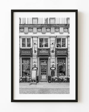 The Napoli pizzeria storefront in Gdańsk has ornate signs and flower boxes in a black and white photograph