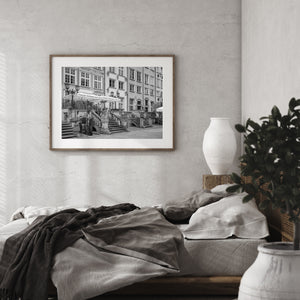 Black and white Polish street photograph with historic shopfronts and decorative stonework