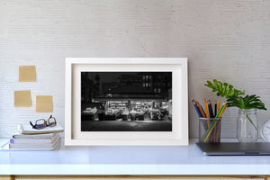 Black and white street photograph of a Polish fruit and vegetable market at night