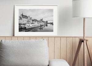 Black and white waterfront photograph with tour boats and historic Polish architecture