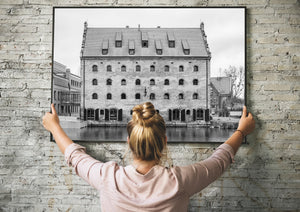 Black and white waterfront architecture with dormer windows and a weathered brick façade