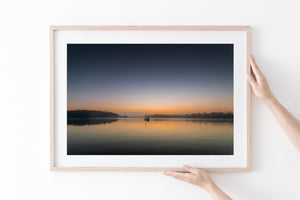 Colorful dawn sky above anchored sailboat