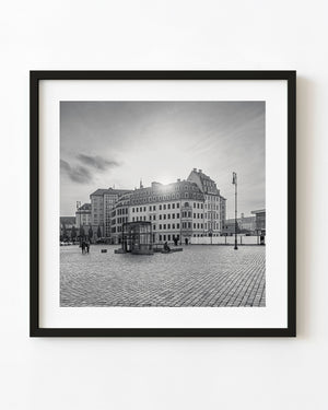 Historic German buildings overlook a cobbled square in a black and white architectural photograph