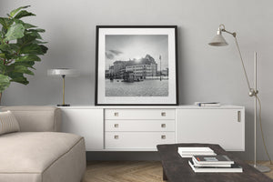 Rows of windows and sloping rooftops face an open cobbled plaza
