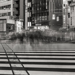 Black and white photo of a city street with a crosswalk and blurred motion effect.