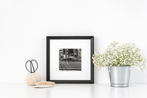 Framed black and white photo on a white surface with decorative items