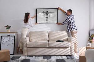 Clouds surround a metal insect sculpture with cutlery and a dangling human figure