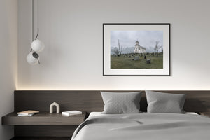 Colour landscape photograph of Gimsøy church with bare trees, grey water and distant mountains