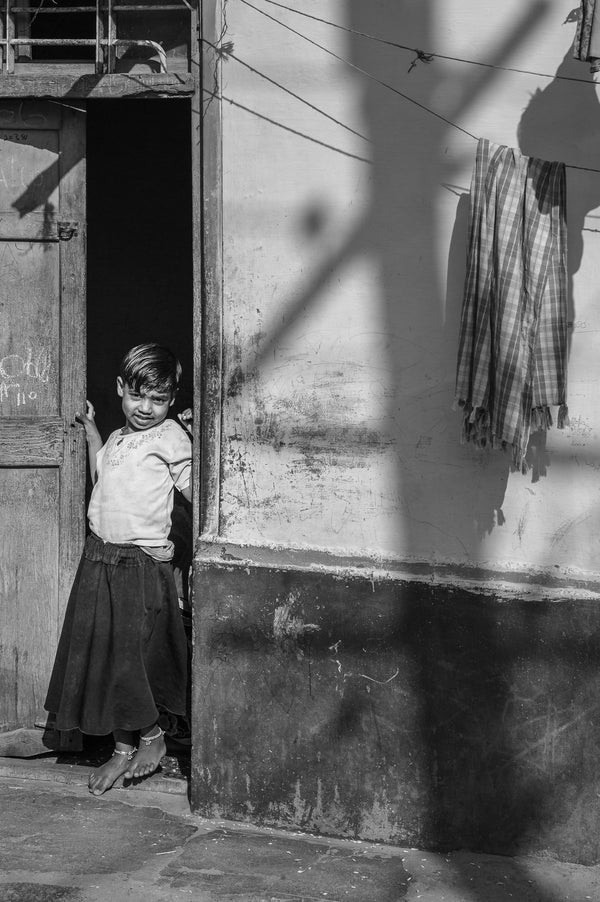 Black and white portrait of girl standing in doorway