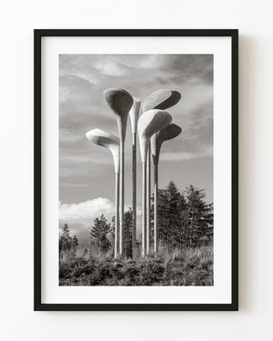 Tall golf-club-shaped sculptures rise above trees at Gleneagles in a black and white photograph