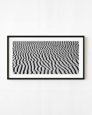 Wind-shaped sand ripples fill a black and white abstract photograph of the Gobi Desert