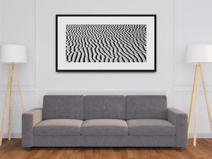 Repeating sand ripple patterns create a textured monochrome desert scene