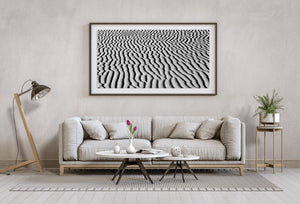 Strong side lighting reveals fine grains and deep shadows between sand ripples