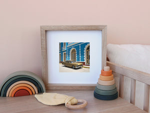 Chrome details and golden bodywork contrast with a blue and white Cuban facade