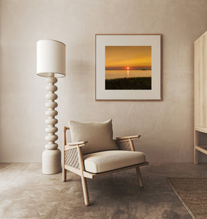 The setting sun and silhouetted shoreline create a tranquil Lake Superior scene