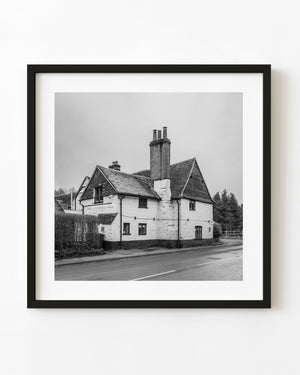 The Gomshall Mill stands beside a village road in a black and white architecture photograph