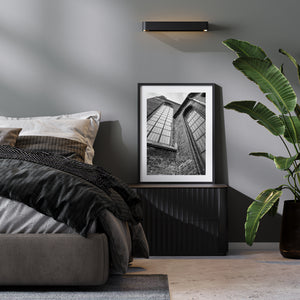 Pointed arches and leaded glass create strong geometric lines against a pale sky