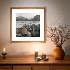 Weathered boulders fill the foreground of a misty Norwegian mountain scene