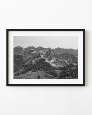 Great Wall watchtowers stretch across rugged mountain ridges in black and white