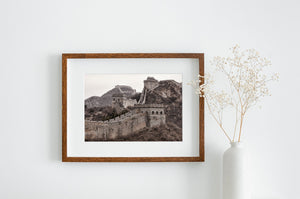 A wide photograph captures the Great Wall winding between mountain watchtowers