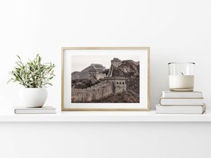 Layered fortifications follow bare hills beneath a pale mountain sky