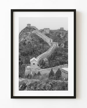 The Great Wall’s winding path climbs toward mountain watchtowers in black and white