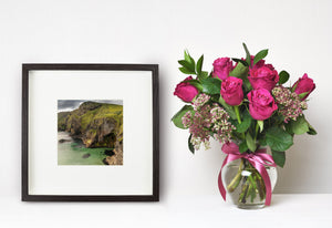 Grass-covered slopes and rugged rock faces frame a sheltered Ballintoy cove