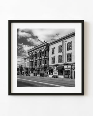 Historic Greenwood storefronts and bay windows line a British Columbia street in black and white