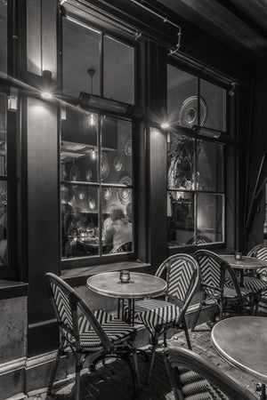 Escena de café callejero con velas y reflejos en las ventanas