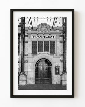 Haarlem railway station’s ornate entrance and iron gate appear in black and white