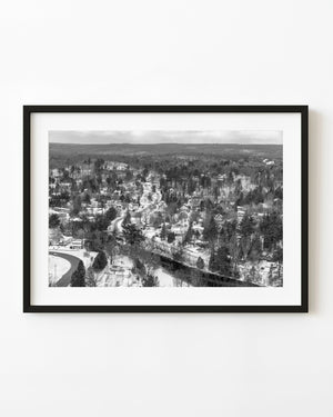 Snow-covered homes and winding roads sit among forested hills in an aerial Haliburton photograph