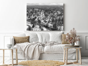 An elevated view captures houses and forest surrounding a winter waterway