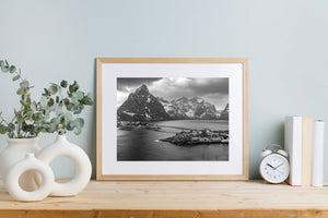 Snow traces steep mountain faces behind a Lofoten waterfront settlement