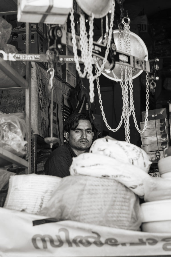 Contemplative worker in hardware store surrounded by tools