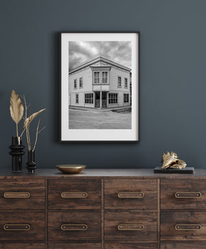 Clouds gather above a two-storey wooden store on a quiet Dawson City street
