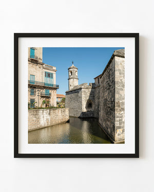 Stone fort walls and moat at Castillo de la Real Fuerza in Havana beneath a clear blue sky.